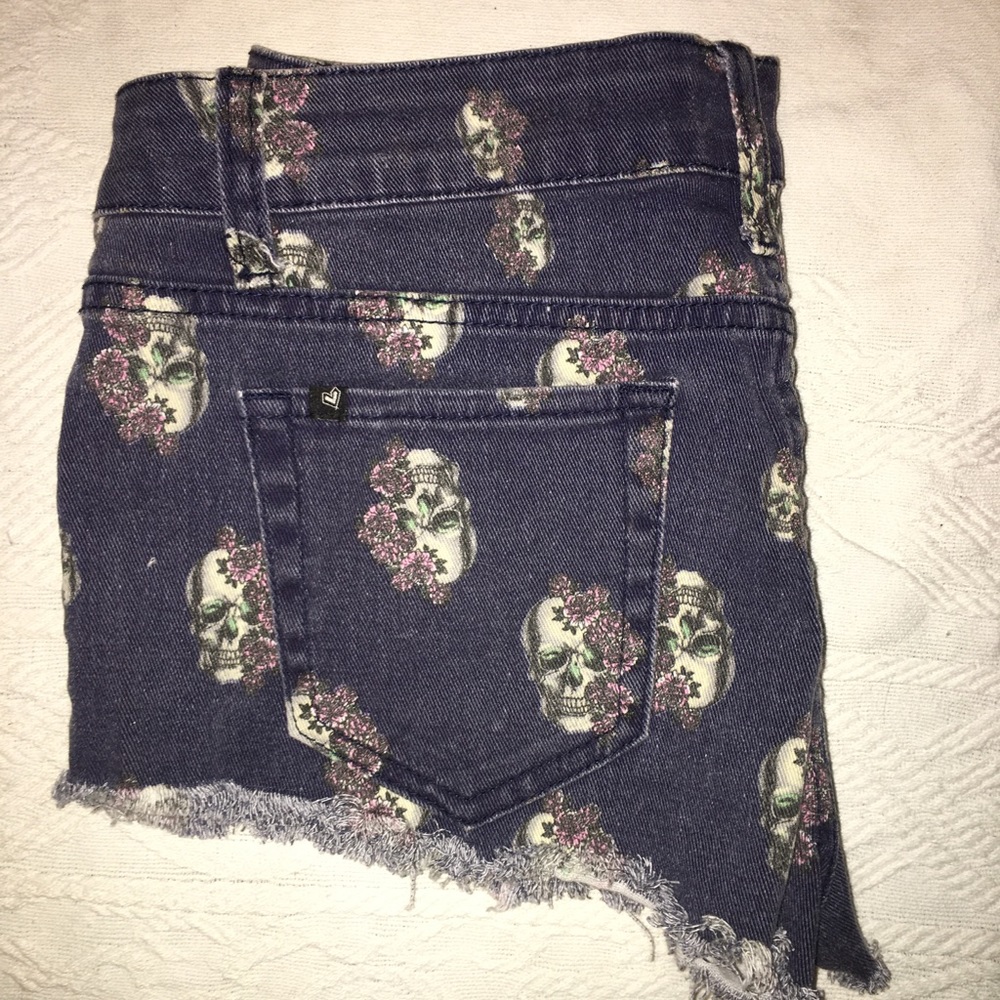 Love sick jean shorts covered in skulls size 9